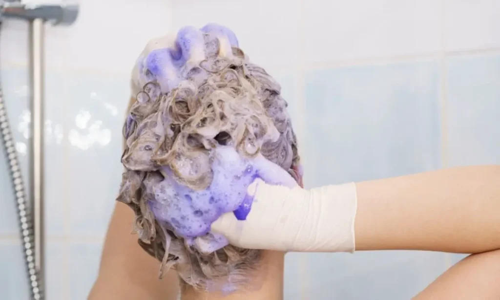 woman applying coloring shampoo best purple shampoo ss featured 1200x720 1